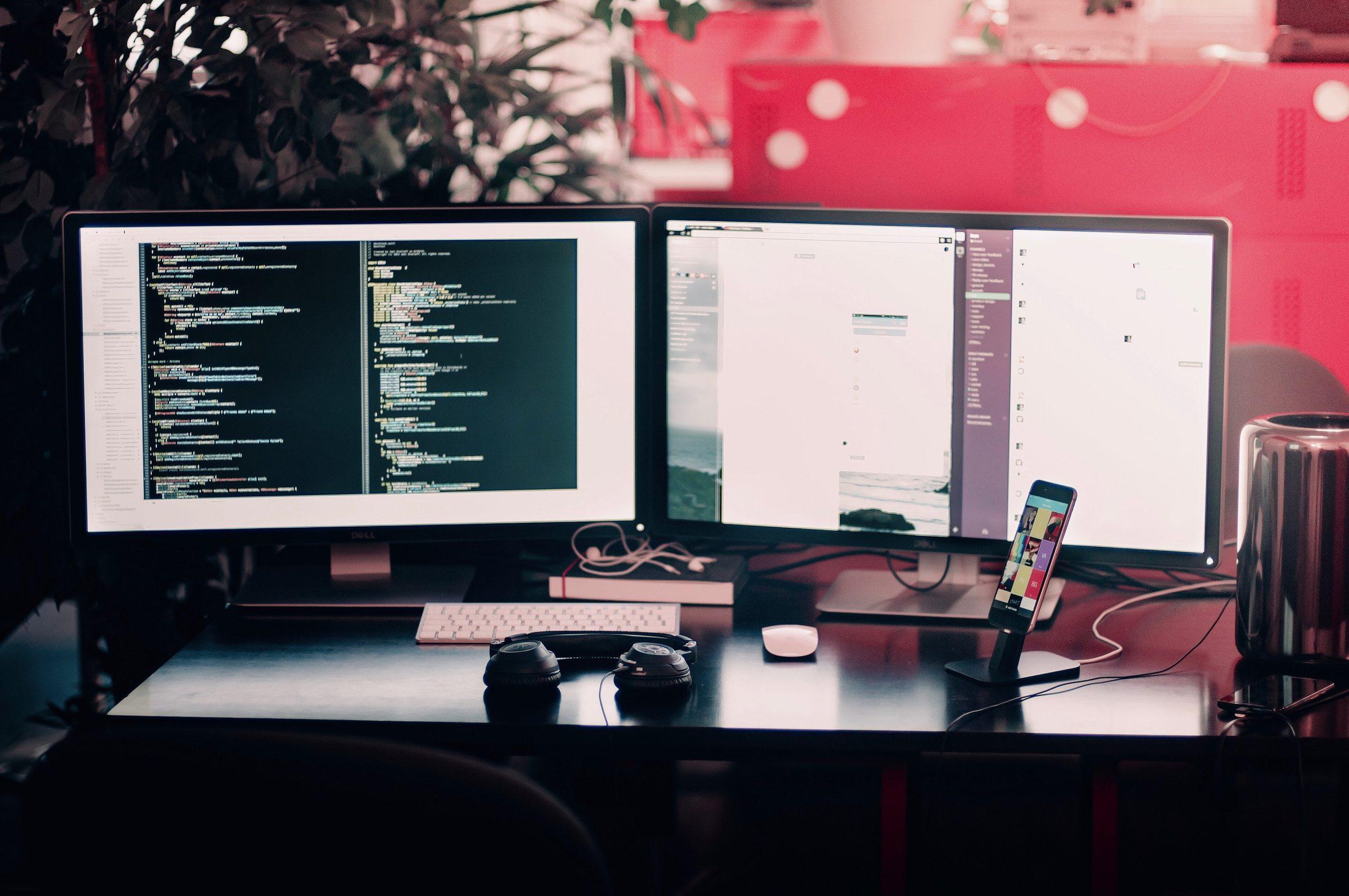 Two monitors full of code on a developer's desk